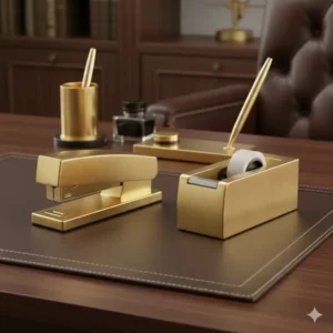 A matching set of polished brass desk accessories, including a stapler and tape dispenser, elevating the look of **luxury office supplies**.