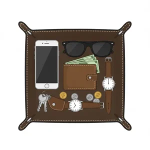 Everyday carry items like a wallet and phone organized inside a mens leather catchall tray.