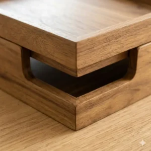 Detail shot showing the recessed base of wooden stackable trays for secure, non-slip stacking.