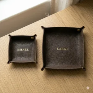 A side-by-side size comparison of small and large custom leather valet tray versions.