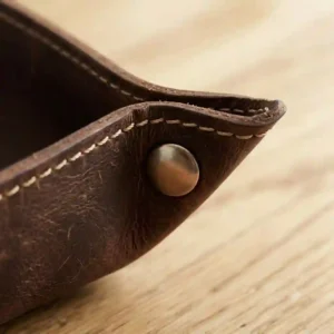 Close-up detail of the fine stitching on a handmade genuine leather tray for keys.