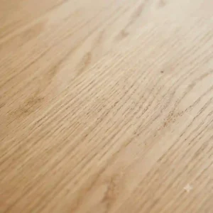 Close-up texture detail of a solid oak minimalist wood desk showing natural wood grain patterns.
