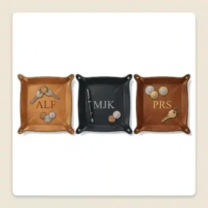 Three different color options of a custom leather valet tray monogram in light brown, black, and dark brown.